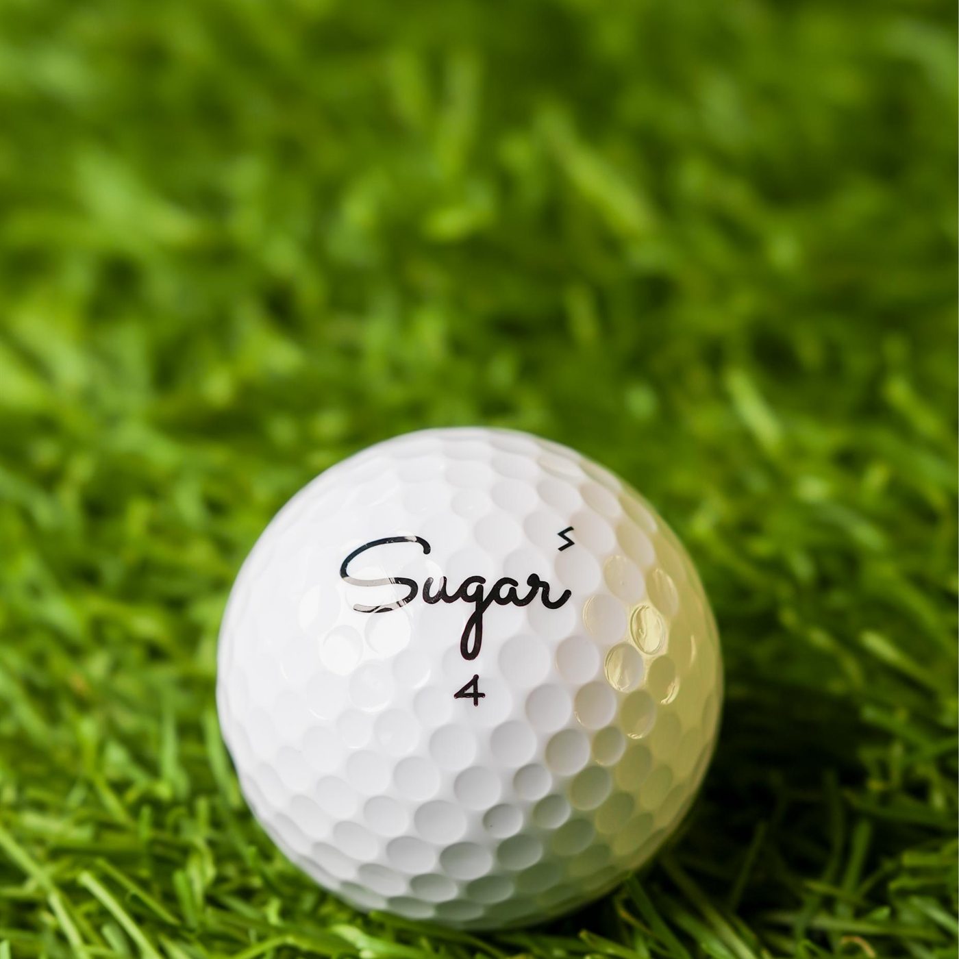 Sugar Soft golf ball on the practice turf, S stamp beside the script logo