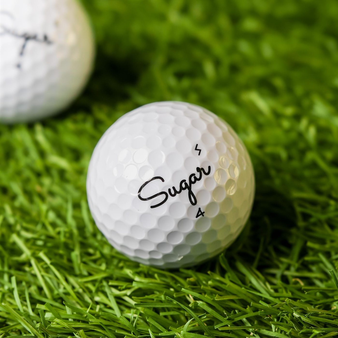 Sugar Soft golf ball on the practice turf, S stamp beside the script logo