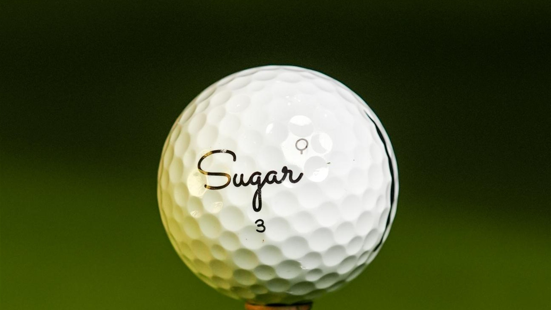 Close-up of a Sugar Quad on the tee, Q stamp above the script logo