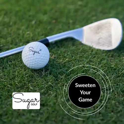 A wedge club and a Sugar Pure urethane golf ball resting on the green grass.